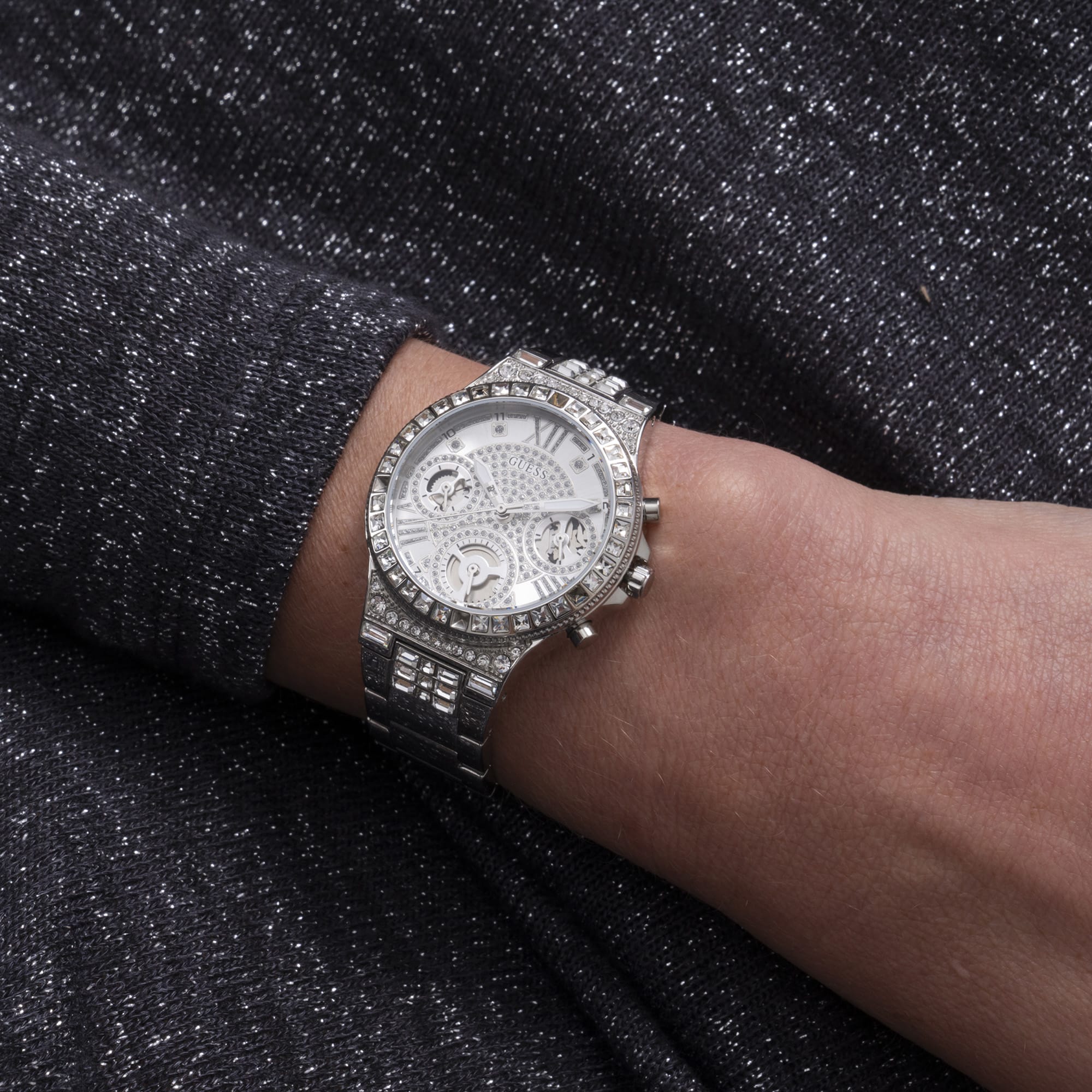 Worn on the wrist, the Guess Moonlight sits comfortably thanks to its chunky link bracelet. The crystal-set case and silver sunray dial add glamorous sparkle to any outfit.