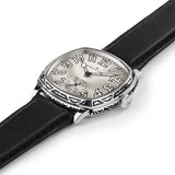 Hamilton American Classic Cushion Mechanical Unisex 34mm Watch H36149710 is captured at a 3/4 angle, showing the white dial, steel case and black leather strap together. The angle highlights the soft cushion shape and the engraved case finish.