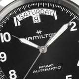 Close-up of Hamilton Khaki Field King H64475531 black dial showing bold Arabic numerals, luminous syringe hands, and curved day-date window at 12 o'clock
