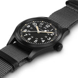 Hamilton Khaki Field Mechanical 38mm Watch H69409930 shows a slim case thickness with a matte black PVD finish over stainless steel. The 20mm lug width and textile strap attachment are visible along the case edge