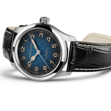 Hamilton Khaki Field Murph Automatic 38mm Watch H70405740 is captured at a 3/4 angle, showcasing the blue-to-black gradient dial, stainless steel case, and black calf leather strap with white contrast stitching. The Interstellar-inspired design and cinematic field watch proportions are prominent from this perspective.