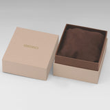 A Seiko branded presentation box with the lid off, showing a brown suede-like cushion inside. The box is a light tan/kraft color with gold 'SEIKO' lettering on the lid, photographed on a neutral light gray background.