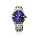 A Seiko Presage Cocktail Time Automatic GMT Men's 40.50mm Watch HCB006J with a silver stainless steel case and link bracelet, featuring a vibrant purple sunburst dial with gold-tone hands and markers.