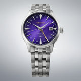 From this angle, the Seiko Presage Cocktail Time Automatic GMT Men's 40.50mm Watch HCB006J shows the purple dial's radial texture and gold accents together with the stainless steel case and bracelet.