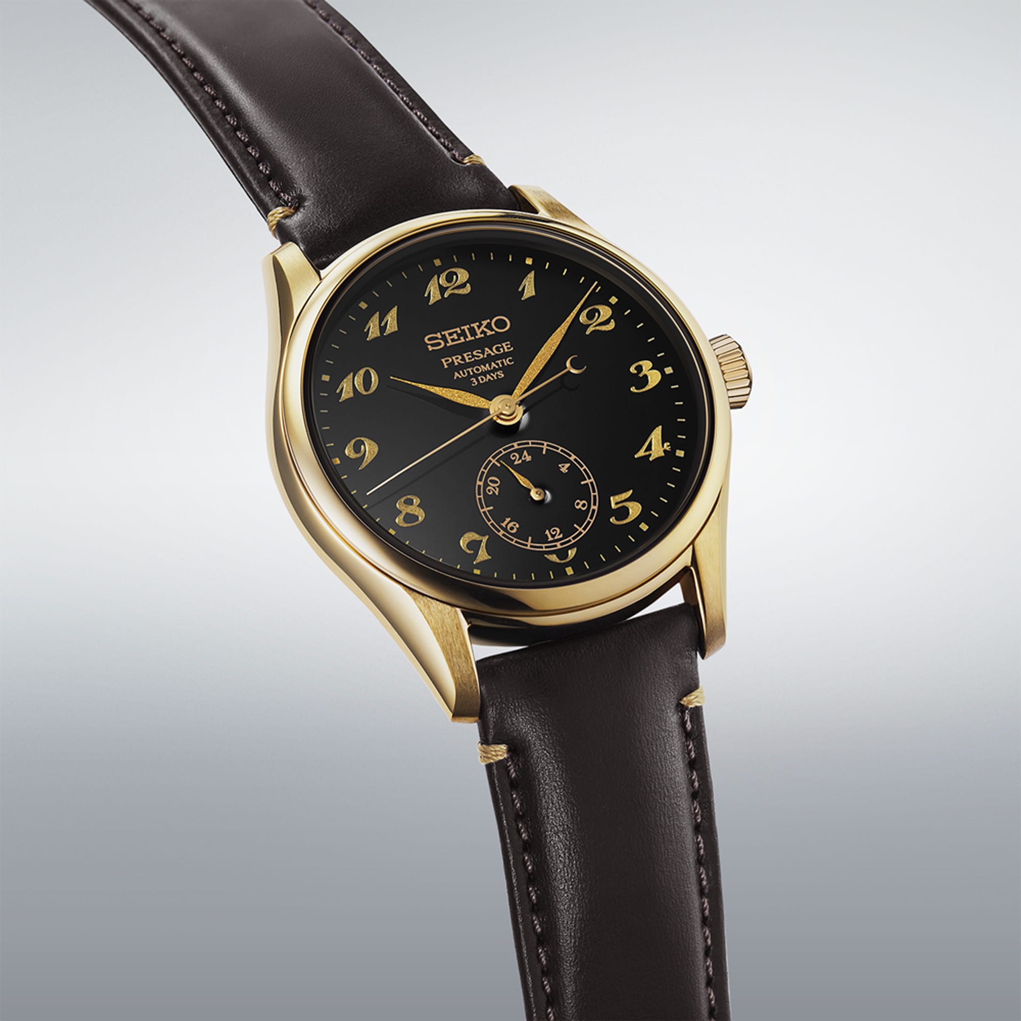 From this angle, the Seiko Presage Automatic 39.60mm Watch HCC006J shows the black urushi dial's depth and gold-lacquer numerals together with the leather strap and gold-coloured case.