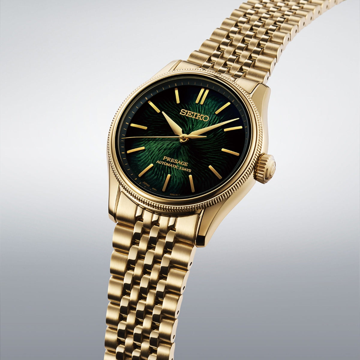 From this angle, the Seiko Presage Automatic 38mm Watch HCC009J shows the matsuba-iro dial's pine bark texture and gold-toned indexes together with the coin-edged bezel and gold-coloured case.