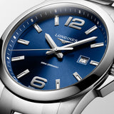 Close-up of the sunray blue dial on the Longines Conquest Men's 43mm Stainless Steel Quartz Watch L3.760.4.96.6. The detail shows the applied Arabic numerals and indexes, silvered polished hands and date display beneath scratch-resistant sapphire crystal.