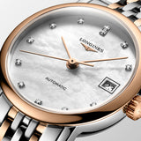 Close-up of the Longines Elegant Automatic dial, showcasing the luminous white mother-of-pearl finish and date display at 3 o'clock. Slim polished hands and refined hour markers reflect the watch's minimalist Swiss design.