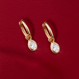 Flat lay view of the Wallace Bishop 0.30 TDW Pear-Cut Lab-Grown Diamond Double Bezel Drop Earrings in 9ct Yellow Gold, reference LGHUGP30, measuring 19mm in length, laid flat. Each earring features a single pear-cut lab-grown diamond in a double bezel setting.