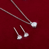 Flat lay view of the Wallace Bishop 0.50 TDW Round Lab-Grown Diamond Solitaire Pendant in Sterling Silver, reference LGPDSS050, on a 500mm (approximately 19.7 inch) fine cable chain, laid flat with the Round Lab-Grown Diamond Solitaire Stud Earrings in Sterling Silver, reference LGERSS050. Each piece features a round lab-grown diamond in a three-claw setting.