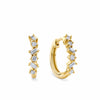 0.20ct TW Lab-Grown Diamond Scatter Huggie Earrings in 9ct Yellow Gold, photographed front on against a plain background. Each huggie earring features a scattered mix of round brilliant and baguette cut lab-grown diamonds.
