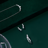 Front-on view of three Wallace Bishop 0.40 TDW Round Lab-Grown Diamond pieces in Sterling Silver: the Ring, reference LGRG040SSO, with nine claw-set diamonds in a chevron V shape on a smooth polished band, the Necklace, reference LGNK040SS, with a chevron-style row of claw-set diamonds on a 500mm (approximately 19.7 inch) cable chain, and the Climber Stud Earrings, reference LGER040SS, with five claw-set diamonds on each earring.