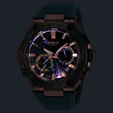 Lume display of the Casio G-SHOCK MRG-B2000KT-3A Limited Edition Men's Solar Watch, 49mm case, showing the Super Luminova-treated hands and indices in low-light conditions. The digital sub-dials remain visible alongside the glowing analogue elements.