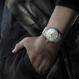 Man wearing King Seiko SJE089J stainless steel watch at boardroom setting, showcasing elegant proportions