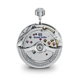 A close-up studio shot of a Grand Seiko automatic watch movement, showing the polished silver-toned steel components, jewel bearings, and crown, with the brand name 'Grand Seiko' and 'GS' logo printed on the plate.