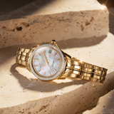 A Seiko Coutura women's quartz watch with a gold-tone stainless steel band and bracelet, a mother of pearl dial.