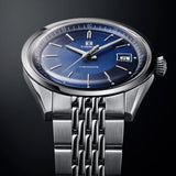 Tissot Visodate 39mm T157.407.11.041.00 front view – deep blue dial, silver stainless steel case, Dauphine hands, index hour markers, date window, grey grains of rice stainless steel bracelet