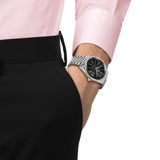Tissot Visodate 39mm T157.407.11.051.00 front view – black dial, silver stainless steel case, Dauphine hands, index hour markers, date window, grey grains of rice stainless steel bracelet on wrist