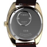 Close-up of the back of a Timex wristwatch with a gold-tone case, dark gray crystal, and brown leather strap visible at the top and bottom.