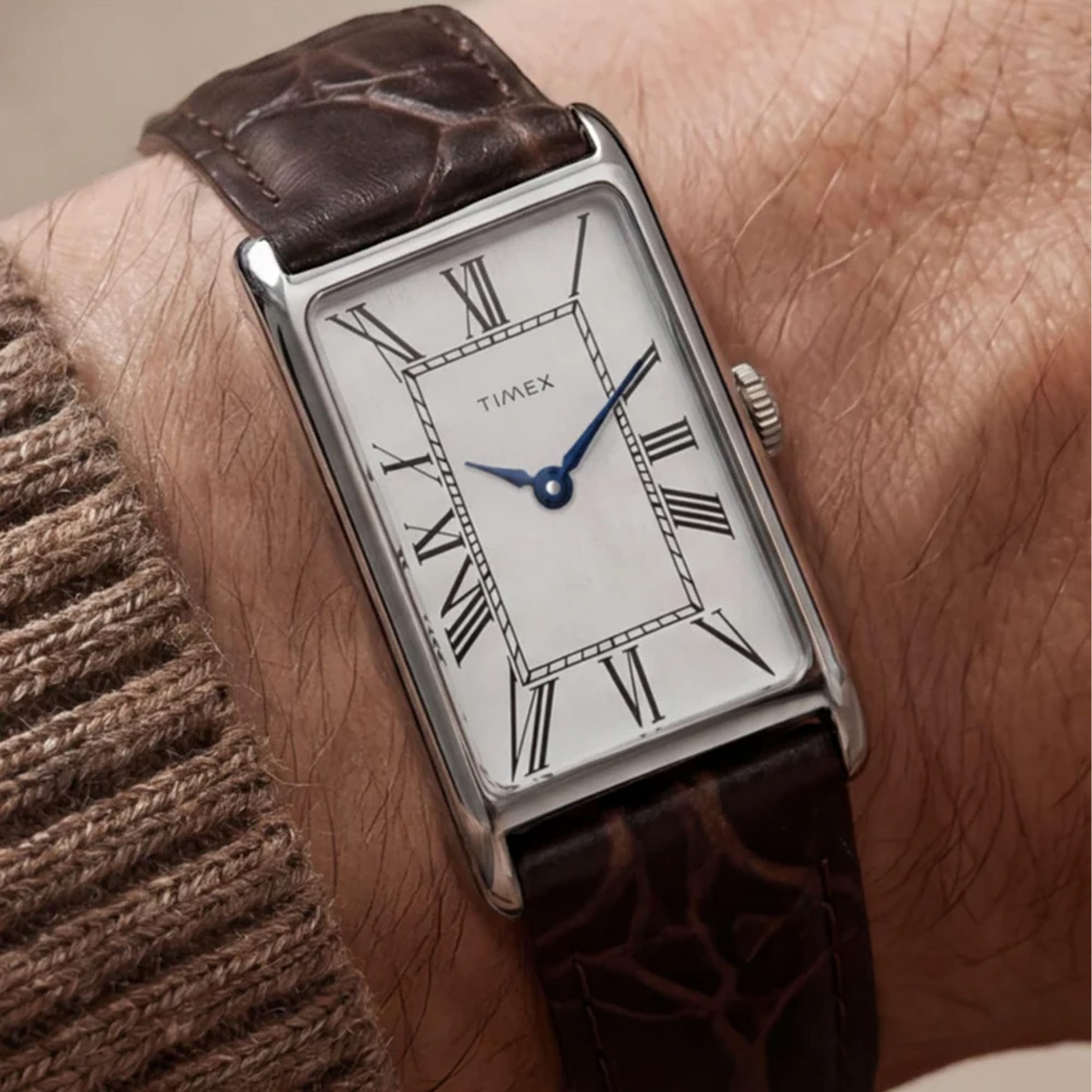 The Timex Lexington Quartz 21mm Watch TW2Y88200 pairs its slim 21mm rectangular stainless steel case with a brown crocodile-grain leather strap for understated 1970s dress-watch styling.