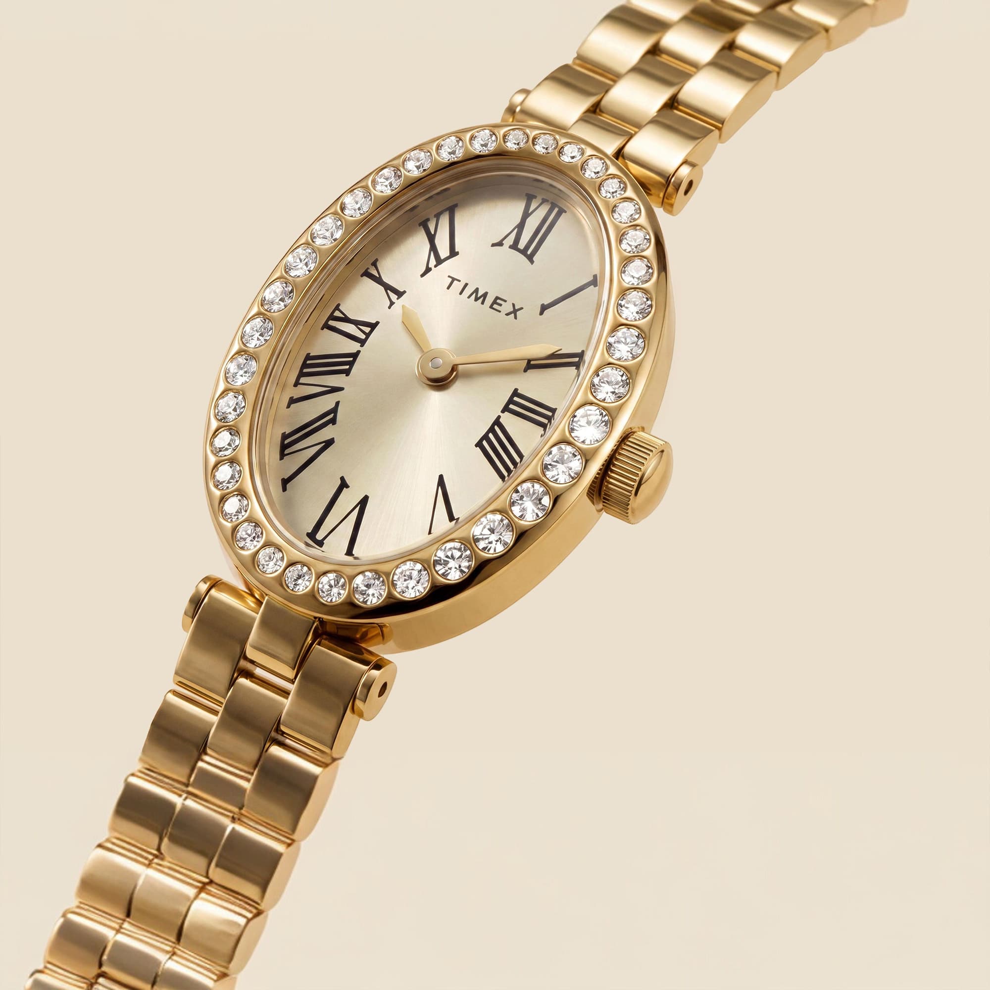 The Timex Cavatina Dress Watch TW2Y90100 highlights the sparkling crystal bezel and the oval case's curved silhouette from this angle. The champagne dial sits neatly within the Gold PVD frame.