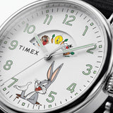 The Timex x Looney Tunes Weekender Quartz 40mm Watch TW2Y99100 has a white dial featuring Looney Tunes characters. The round silver-tone case frames the playful, nostalgic design.