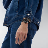 TAG Heuer Formula 1 Date WAZ1110.FT8023 shown worn on the wrist, illustrating the case proportions and rubber strap fit. The black dial stands out against the denim jacket sleeve in frame.