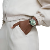 TAG Heuer Carrera Date WBN2317.BA0001 shown worn on the wrist, illustrating the case proportions and steel bracelet fit. The green dial stands out against the sleeve in frame.