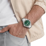 TAG Heuer Aquaracer Professional 200 Solargraph WBP1118.BA0047 shown worn on the wrist, illustrating the case proportions and steel bracelet fit. The green dial stands out against the tan jacket sleeve in frame.
