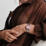 TAG Heuer Aquaracer Professional 200 Solargraph WBP1318.BA0005 shown worn on the wrist, illustrating the case proportions and steel bracelet fit. The pink dial stands out against the sleeve in frame.