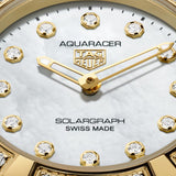 TAG Heuer Aquaracer Professional 100 Solargraph WBP1420.BB0006 captured in extreme close-up on the white mother-of-pearl dial, highlighting the dodecagonal diamond hour markers and gold-plated hands. The Super-LumiNova-filled hands sit against the pearlescent dial surface.