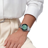 TAG Heuer Aquaracer Professional 300 Date WBP231K.BA0618 shown worn on the wrist, illustrating the case proportions and steel bracelet fit. The turquoise dial stands out against the sleeve in frame.