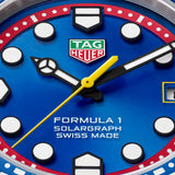 TAG Heuer Formula 1 Solargraph x Oracle Red Bull Racing WBY111F.BA0042 captured in extreme close-up on the blue opalin dial, highlighting the black lacquered indexes, yellow central hand, and date window at 3 o’clock. The red flange frames the dial edge.
