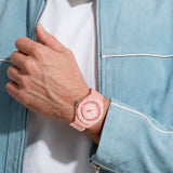 TAG Heuer Formula 1 Solargraph WBY1165.FT8115 shown worn on the wrist, illustrating the case proportions and pink rubber strap fit. The pastel pink dial stands out against the light blue jacket sleeve in frame.