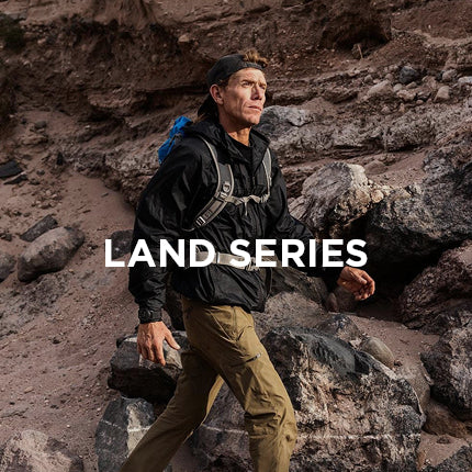 Man hiking on rocky terrain with 'LAND SERIES' text overlay
