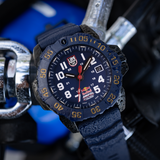 Luminox Navy SEAL Red Bull Ampol Racing Edition Men's 46mm Quartz Watch XS.3501.ARB.N shown in a motorsport-inspired setting. This limited edition Navy SEAL 3500 Series dive watch features a blue dial, a lightweight CARBONOX™ case and 200m water resistance.