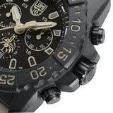 Close-up of the black dial on the Luminox Navy SEAL Foundation Men's 45mm Quartz Chronograph Watch XS.3590.NSF.SET, showing the sand-coloured details, three chronograph sub-dials and the Navy SEAL Foundation logo at 6 o'clock. This Navy SEAL Foundation Chronograph features luminous hands and markers with self-powered tritium tubes.