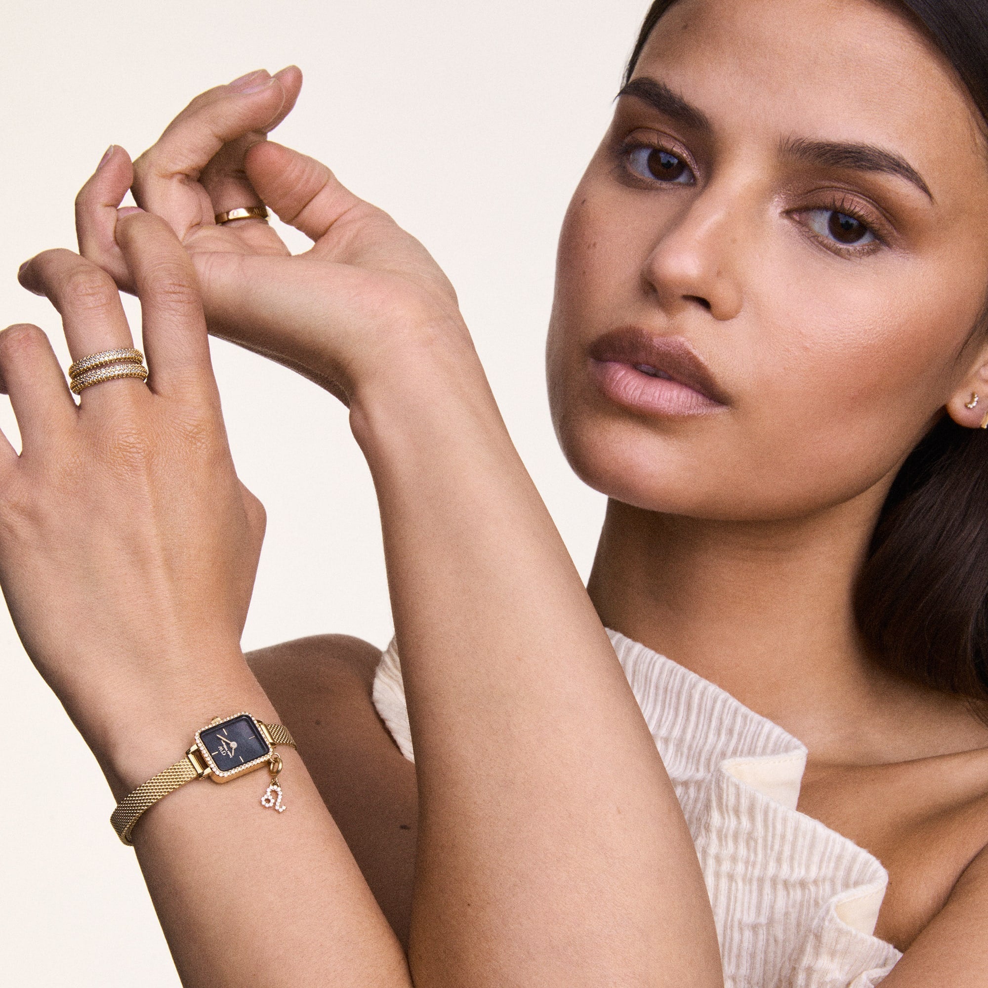 Woman wearing a gold watch and rings 