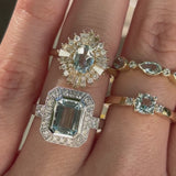 Four aquamarine and diamond rings on a hand