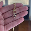Video of a Wallace Bishop Charm Holder Chain in 9ct Yellow Gold, 500mm (approximately 19.7 inches) in length, with the Heart Rhodolite Garnet Double Bezel Pendant in 9ct Yellow Gold, reference 93PDHTRH1Y, added to it. The pendant features a 5mm heart cut rhodolite garnet in a polished gold double bezel.