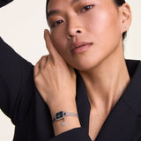 Woman wearing a Daniel Wellington Watch with a silver mesh band. 
